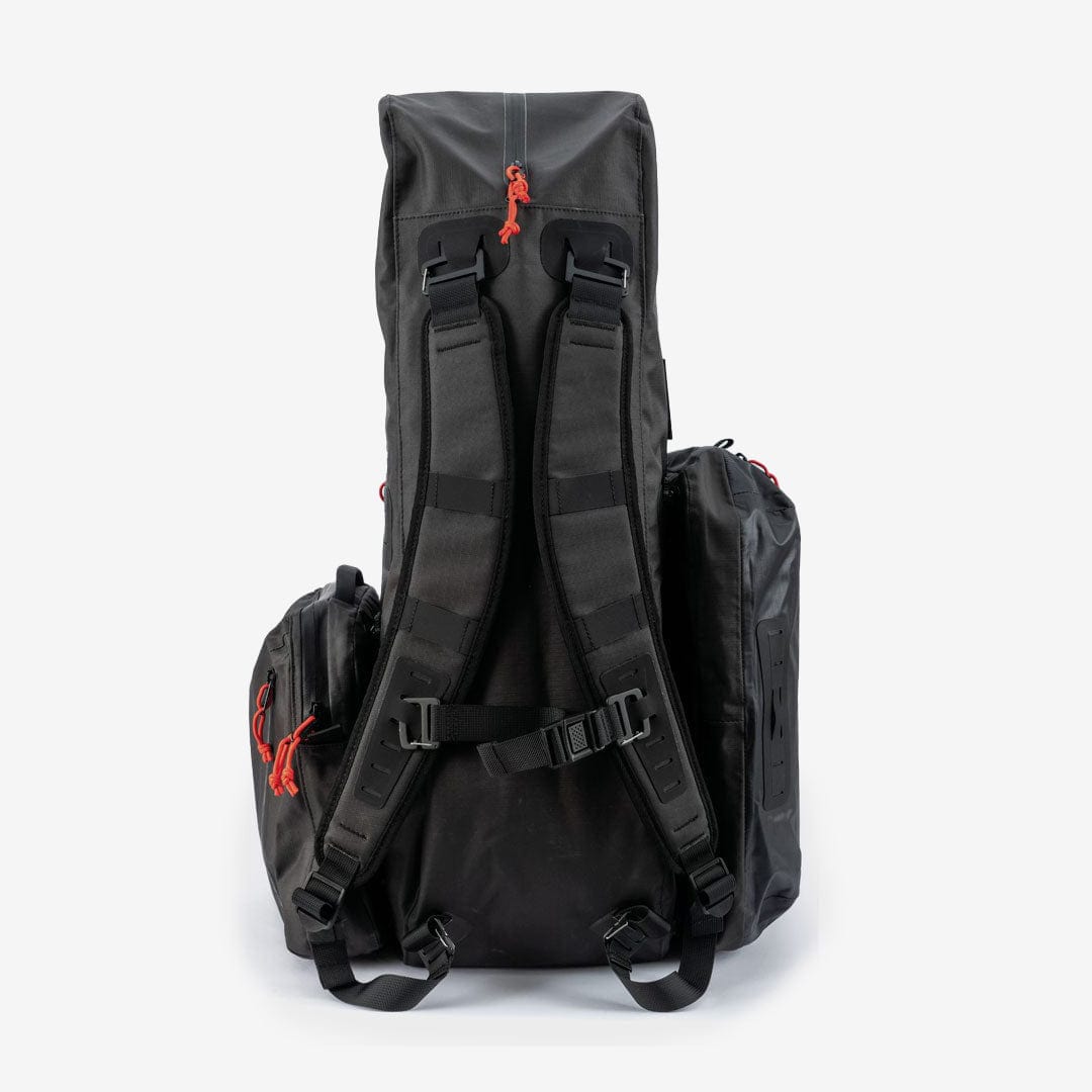 The Cancha Original Racquet Bag (25L) is a black, rugged, high-capacity backpack featuring padded shoulder straps, red zipper pulls, and multiple external pockets. Made from lightweight water-repellent materials, it is designed for outdoor or travel use.