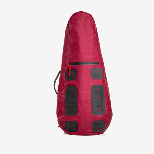 Introducing The Original Racquet Bag (15L) by Cancha—a lightweight, maroon teardrop-shaped tennis racquet bag featuring sleek black rectangular accents and a secure zipper. This water-repelling bag includes a convenient handle on one side, ensuring your equipment stays dry. Customize with add-ons for personalized functionality and style.