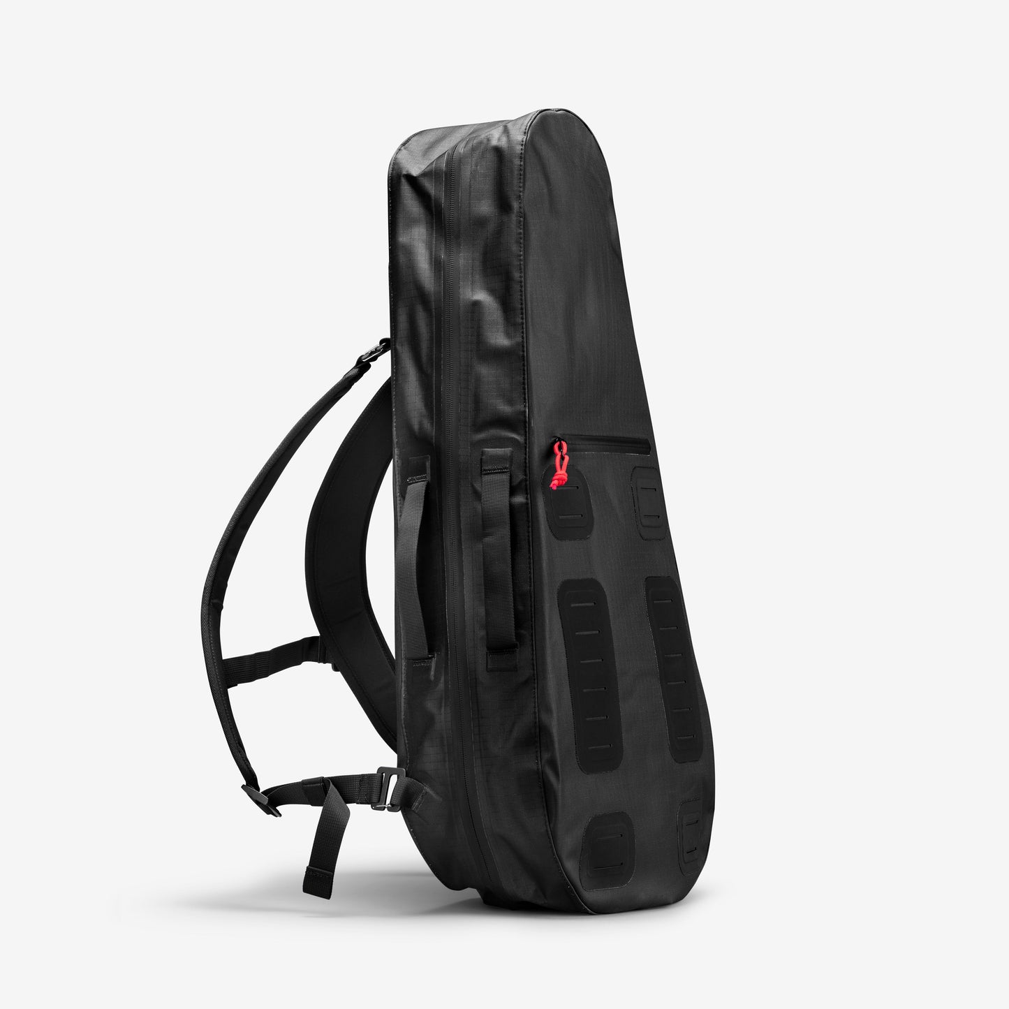 A Racquet Bag Voyager from Cancha, in sleek black with backpack straps, crafted from weatherproof materials and equipped with multiple compartments including a pocket featuring a red zipper pull, stands upright against a white background.